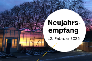 Erleuchtetes Gewächshaus der BHT vor rötlichem Himmel bei Sonnenaufgang